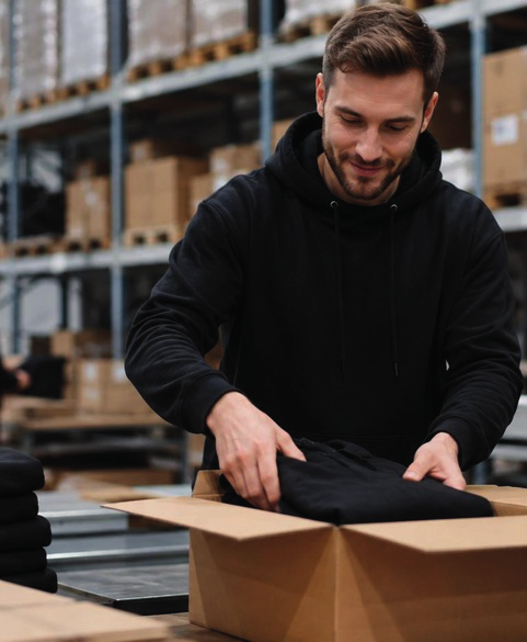 Mitarbeiter verpackt Textilien im Fulfillment Center